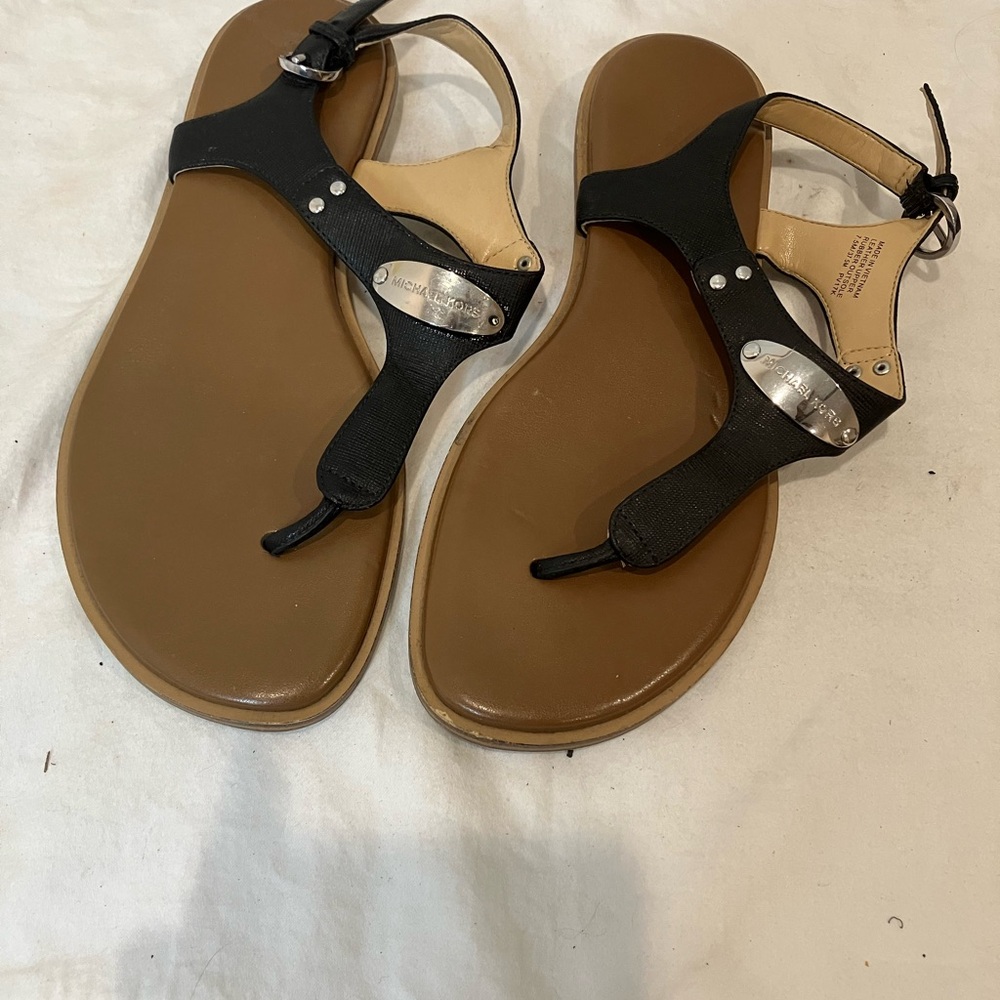 Michael Kor leather thongs in black and tan heal buckles. Size 7.5.